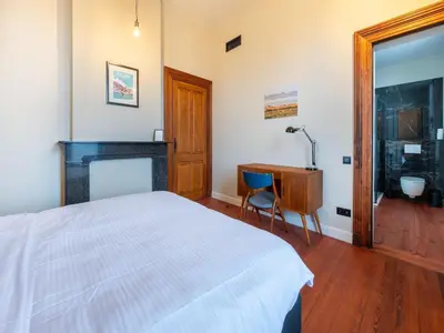 a bedroom with a bed and a desk and a table at Picturesque mansion with garden in Tongeren in Tongeren