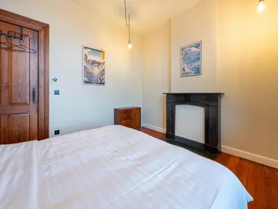 a bedroom with a bed and a fireplace at Picturesque mansion with garden in Tongeren in Tongeren