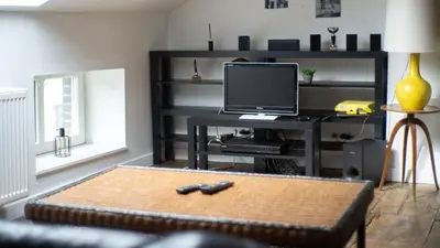 a living room with a television and a remote control at Nomad Home - Bronckart 10 in Liège