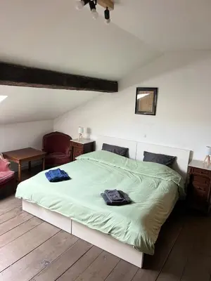 a bedroom with a large bed with green sheets at Nomad Home - Bronckart 10 in Liège
