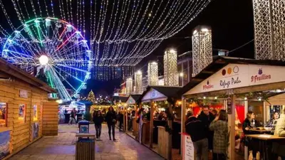 a ferris wheel and a crowd of people at a market at Le Liégeois - Confort au Centre Ville in Liège
