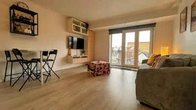 a living room with a couch and a table at Le Liégeois - Confort au Centre Ville in Liège