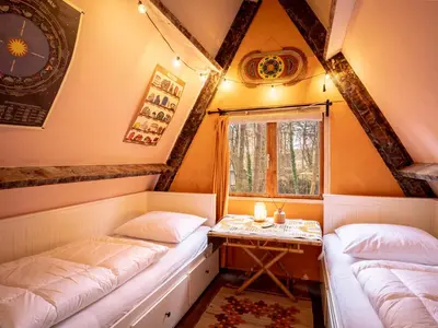 two beds in a room with a table and a window at Boshuisje Rekem - Tanuki in Lanaken