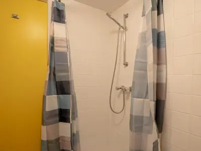 a shower with a shower curtain in a bathroom at Boshuisje Rekem - Tanuki in Lanaken