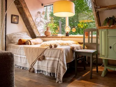 a bedroom with a bed with a table and a window at Boshuisje Rekem - Tanuki in Lanaken