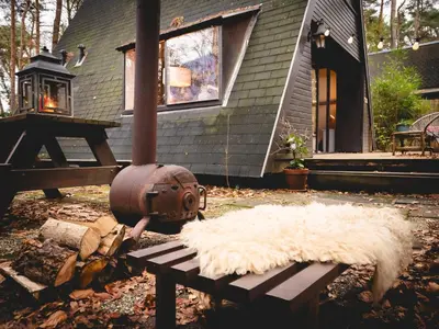 a house with a fire hydrant next to a bench at Boshuisje Rekem - Tanuki in Lanaken