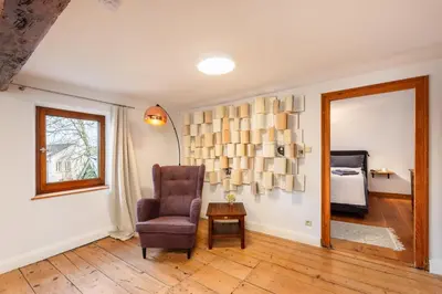 a living room with a chair and a table at Zum Alten Kuhstall - Südgarten & Terrasse - Großes Landhaus mit Sauna in Lontzen