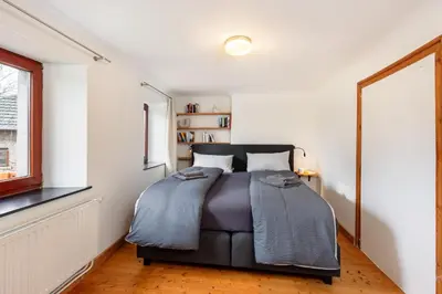 a bedroom with a bed and a window at Zum Alten Kuhstall - Südgarten & Terrasse - Großes Landhaus mit Sauna in Lontzen