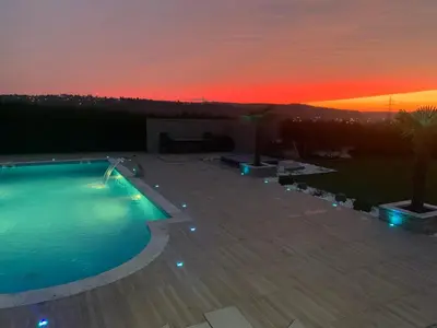 a swimming pool with a sunset in the background at Villa a Chaudfontaine in Chaudfontaine