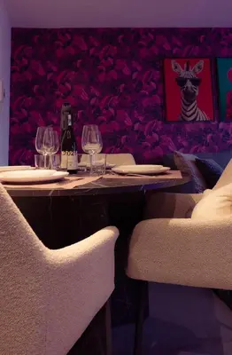 a table with two chairs and wine glasses on it at SuiteDreams - Ruby Suite Liège in Liège