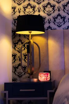 a lamp sitting on a table in a bedroom at SuiteDreams - Ruby Suite Liège in Liège