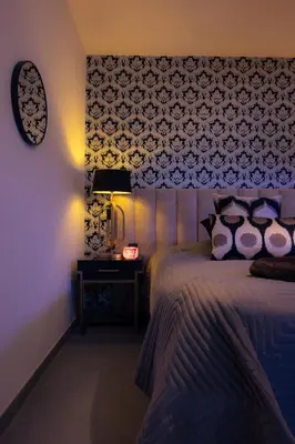 a bedroom with a bed and a clock on the wall at SuiteDreams - Ruby Suite Liège in Liège