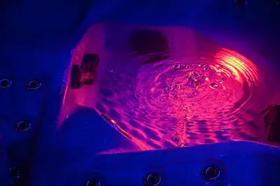 a bathtub with a red light in the water at SuiteDreams - Ruby Suite Liège in Liège