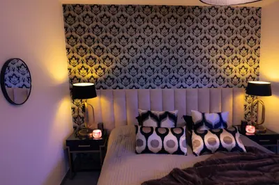 a bedroom with a bed with pillows and two lamps at SuiteDreams - Ruby Suite Liège in Liège