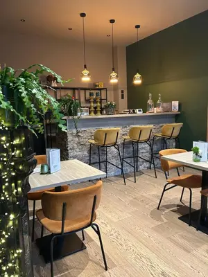 a restaurant with tables and chairs and a bar at Logies-Bistro Rosa in Maaseik