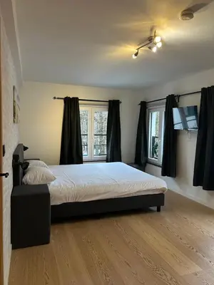 a bedroom with a large bed in a room at Logies-Bistro Rosa in Maaseik