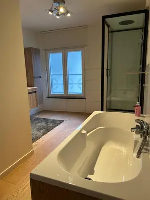 a bathroom with a large white bath tub with a mirror at Logies-Bistro Rosa in Maaseik