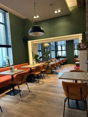 a dining room with tables and chairs and windows at Logies-Bistro Rosa in Maaseik