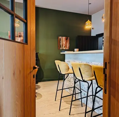 a kitchen with a table with chairs and a green wall at Logies-Bistro Rosa in Maaseik