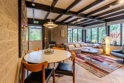 a living room with a table and chairs at Lux Bos Chalet in Lanaken