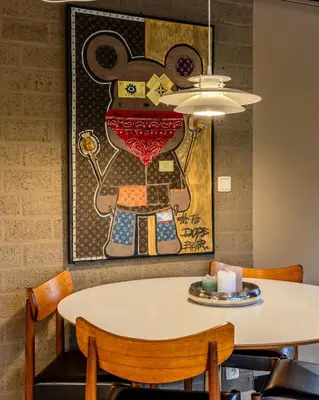 a table and chairs with a painting on the wall at Lux Bos Chalet in Lanaken