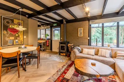 a living room with a couch and a table at Lux Bos Chalet in Lanaken
