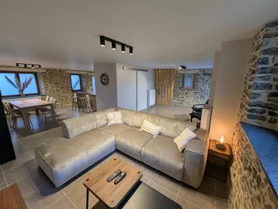 a living room with a couch and a table at Le Marie-Rose Charme et Pierre Porte des Fagnes in Baelen
