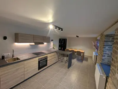 a kitchen with a sink and a table and a dining room at Le Marie-Rose Charme et Pierre Porte des Fagnes in Baelen