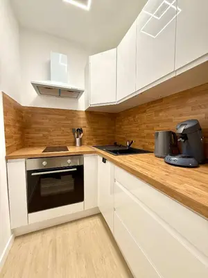 a kitchen with white cabinets and a stove top oven at Studio moderne au coeur du quartier Saint Adalbert in Liège