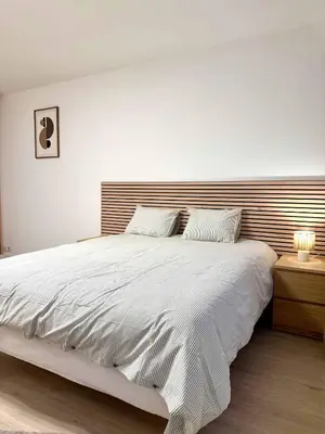 a bedroom with a large bed with a wooden headboard at Studio moderne au coeur du quartier Saint Adalbert in Liège
