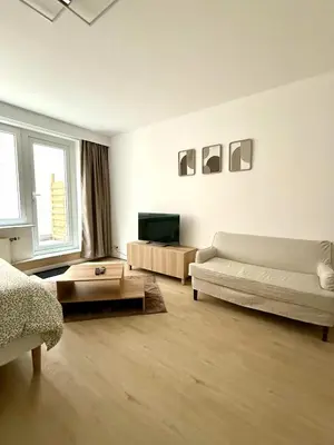a living room with a couch and a table at Cosy studio en plein centre pour 2 personnes in Liège