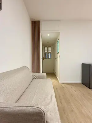 a bedroom with a bed and a hallway with a door at Cosy studio en plein centre pour 2 personnes in Liège