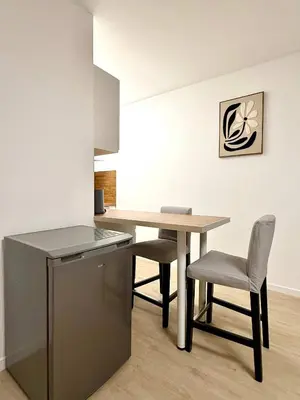 a kitchen with a table and chairs in a room at Cosy studio en plein centre pour 2 personnes in Liège