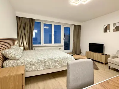 a bedroom with a bed and a large window at Cosy studio en plein centre pour 2 personnes in Liège