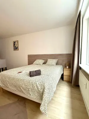a bedroom with a bed with a white comforter at Cosy studio en plein centre pour 2 personnes in Liège