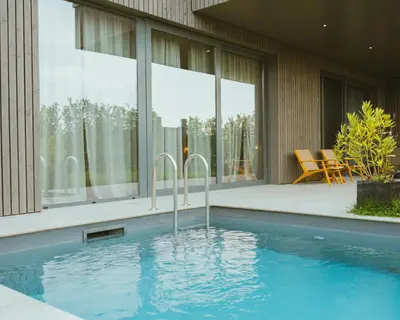 a swimming pool in front of a house at Nomad Village in Verviers