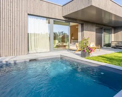 a swimming pool in front of a house at Nomad Village in Verviers
