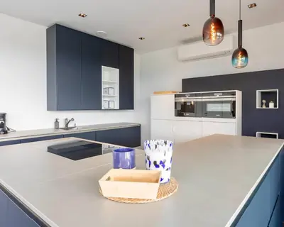 a kitchen with blue and white cabinets and a counter at Nomad Village in Verviers