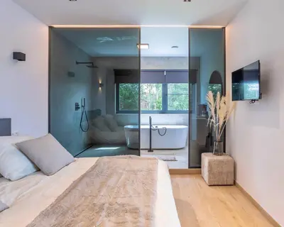 a bedroom with a large bed and a bath room at Nomad Village in Verviers