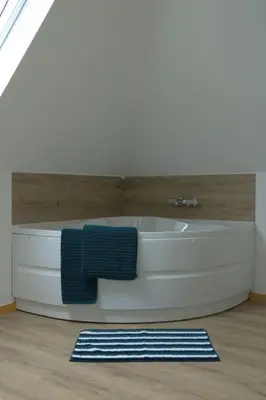 a bath tub in a bathroom with a blue towel at Holiday Home Heidebos für 8 Personen by Interhome in Oudsbergen
