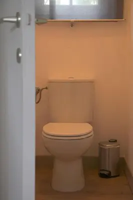 a white toilet in a bathroom with a window at Holiday Home Heidebos für 8 Personen by Interhome in Oudsbergen