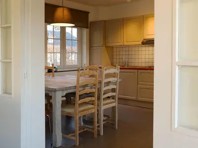 a kitchen with a wooden table and chairs at Holiday Home Heidebos für 8 Personen by Interhome in Oudsbergen