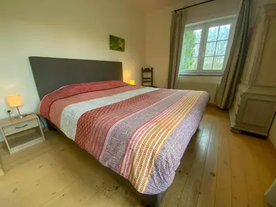 a bedroom with a large bed and a window at Holiday Home Heidebos für 8 Personen by Interhome in Oudsbergen