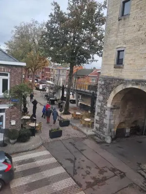 a group of people walking down a street near a building at Domus moerenpoort in Tongeren