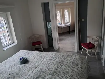 a bedroom with a bed and two chairs and a bathroom at Domus moerenpoort in Tongeren