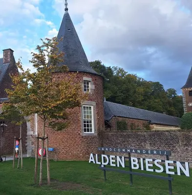 an old brick building with a sign in front of it at Villa Bonifica in Riemst