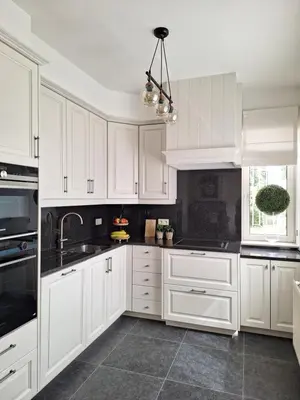 a white kitchen with white cabinets and a sink at Villa Bonifica in Riemst