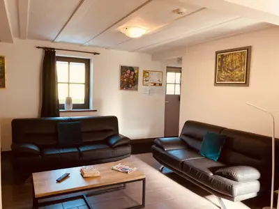 a living room with two leather couches and a coffee table at De Molenhoeve Gezinswoning in Voeren