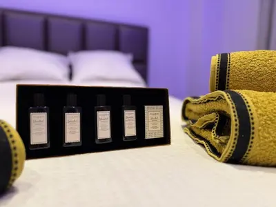 a black box on a bed next to a purse at Suite Luxueuse avec jaccuzi sans vis-à-vis in Liège