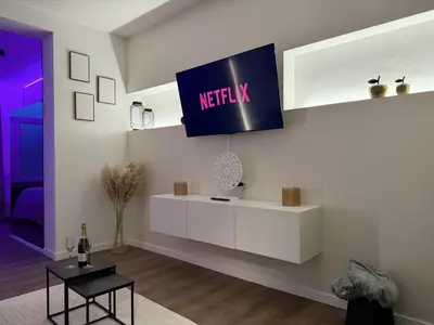 a living room with a netflix sign on the wall at Suite Luxueuse avec jaccuzi sans vis-à-vis in Liège